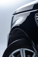 close up view of new black automobile on grey backdrop