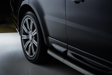 Obraz na płótnie Canvas close up view luxury shining black automobile on dark background