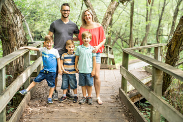 Fototapeta premium happy young family in forest having fun together