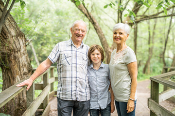 Grandparents with grandkid on summer forest having great time