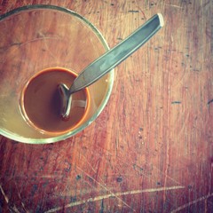 Top view of Coffee in a clear glass with spoon on a wooden table.