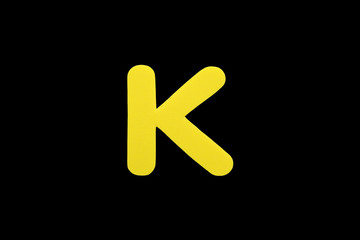 Alphabet letter K symbol of sponge rubber isolated over black background.