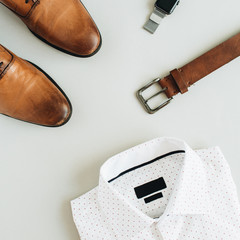 Men's fashion composition with watch, shirt, belt and shoes. Flat lay, top view modern clothes.