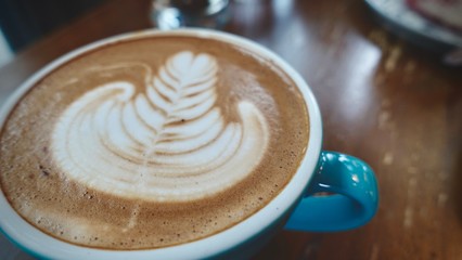 close up of A cup of hot latte art or cappuccino coffee on wooden table  