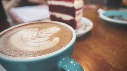 close up of A cup of hot latte art or cappuccino coffee on wooden table 