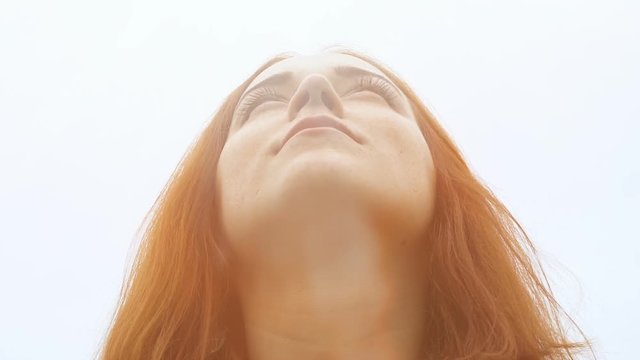 Blessed woman looks up to sky, God's light above head, female with holy spirit