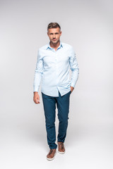 handsome adult man in stylish clothes looking at camera on white