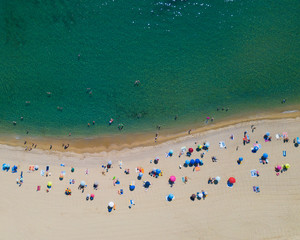 tourists on the beach with waves from above