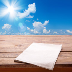 Wooden deck table with towel over summer background. Kitchen background, product montage display. Mock up .