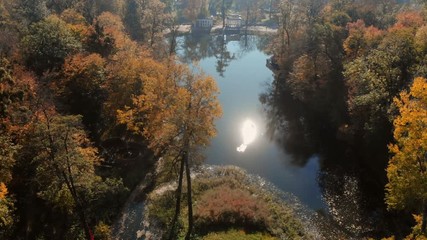 drone shot above water surface in autumn forest