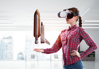 Girl in checked shirt wearing VR glasses experiencing another reality. Mixed media