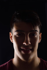 dark portrait of a young man on black background