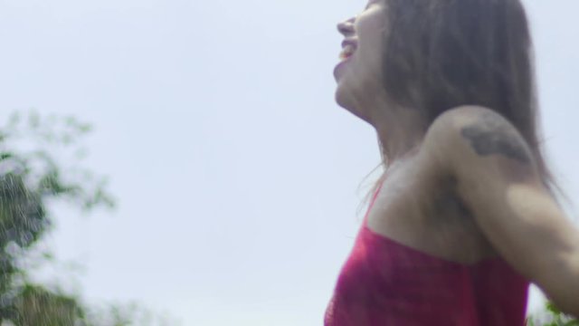 Woman in rain catharsis, female cries laughs in summer rain through sunshine