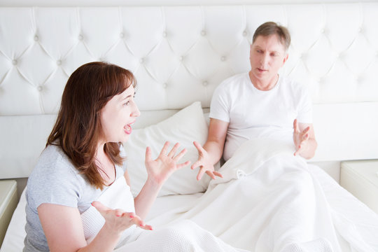 Caucasian middle age family couple angry shouting in bed. Conflict relationship concept. Husband and wife dialogue. Selective focus