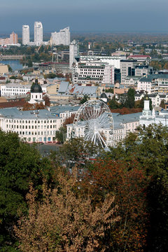 panorama. Autumn in the city. Ferris wheel, houses and trees in Podol, Kiev. Ukraine. blue sky and clouds in the background