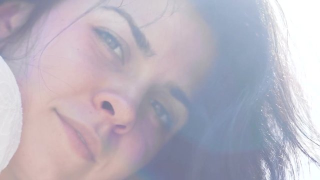 Beautiful female looks in camera low angle shot, pretty dark hair slow motion