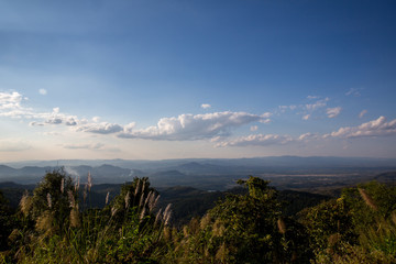 Fototapeta premium green field and blue sky with light clouds.Mountains during sun rises . Beautiful natural landscape in the northeast of Thailand 