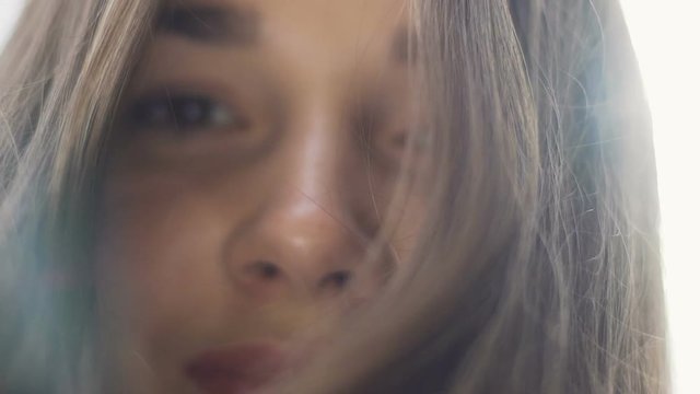 Mother looks down on child pov, smiling woman loving eyes long hair sun rays