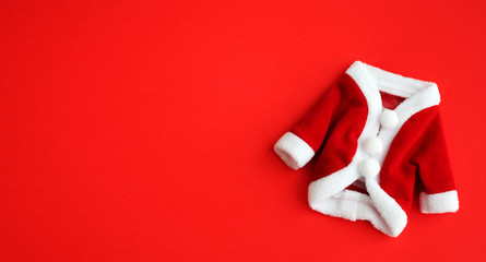 Christmas background Santa Claus (Saint Nicholas) mini coat suit costume with white cuffs flat lay...