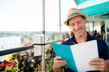 Young man sitting tourist sit for the breakfest with coffee holding menu