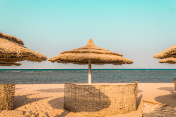 Obraz premium beach umbrellas made from natural materials by the sea