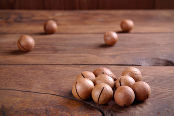 Macadamia nuts on a wooden background.