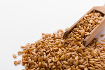 Seeds of golden flax on a white background