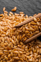 seeds of golden flax on a dark stone background