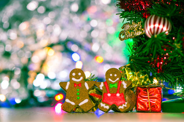 Cute gingerbread man with christmas tree and blurry sparkle background, close up, bokeh, text space(copy space)