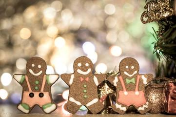 Cute gingerbread man with christmas tree and blurry sparkle background, close up, bokeh, text space(copy space)