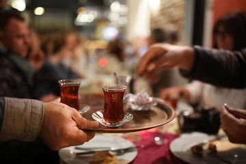 Man serving delicious Turkish tea. - obrazy, fototapety, plakaty