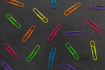 Colorful paperclips stationery abstract dark background