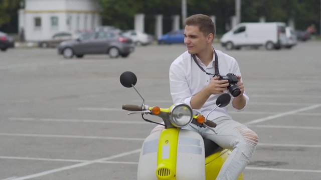 Young guy on a scooter makes a photo