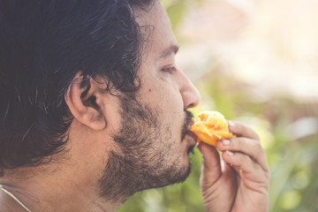 Indian man eating mango.