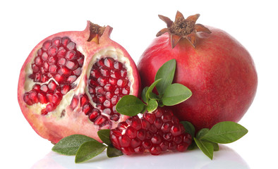 Big red pomegranate fruit and half pomegranate with green leaves on white isolated background