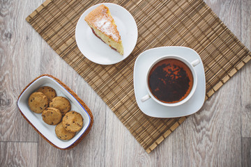 Fototapeta na wymiar freshly baked biscuit plum cake and a hot cup of tea