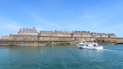 Vue sur les remparts de Saint-Malo, avec un bateau s’apprêtant à accoster (France)