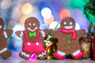 Obraz na płótnie Canvas Cute gingerbread man with christmas tree and blurry sparkle background, close up, bokeh, text space(copy space)
