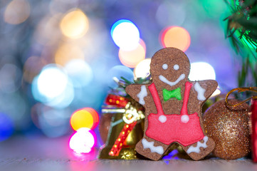 Obraz na płótnie Canvas Cute gingerbread man with christmas tree and blurry sparkle background, close up, bokeh, text space(copy space)