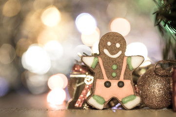 Cute gingerbread man with christmas tree and blurry sparkle background, close up, bokeh, text space(copy space)