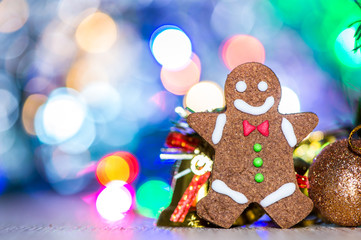 Cute gingerbread man with christmas tree and blurry sparkle background, close up, bokeh, text space(copy space)