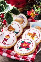 Obraz na płótnie Canvas Christmas butter cookies decorated with Christmas graphics, on wooden table. Close up