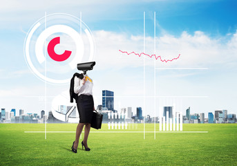 Camera headed woman standing on green grass against modern cityscape