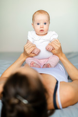 Portrait of a beautiful mother with her 2 month old baby in the bedroom