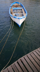 Fishing boat tied to the pier and a beautiful beach
