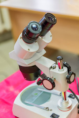 Laboratory Equipment, Optical Microscope for school lessons on red table