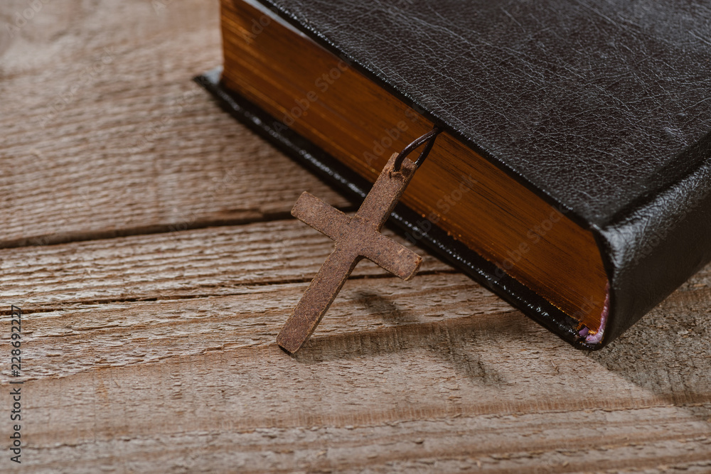Wall mural close-up shot of holy bible with cross on wooden table - Wall murals