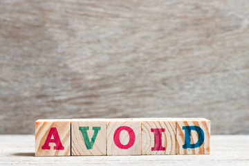 Letter block in word avoid on wood background