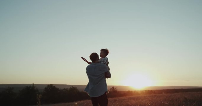 Beautiful sunset , dad with his son , three years old , playing and running through a field , just awesome view.