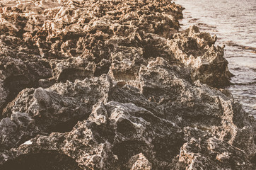 Rocky shore with sharp edges washed by the ocean
